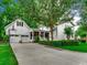Exterior view of home showcasing a two-car garage, driveway and mature landscaping at 9 Winnowing Way, Pawleys Island, SC 29585