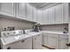 Functional laundry room with white cabinets, modern washer and dryer, and ample counter space at 9 Winnowing Way, Pawleys Island, SC 29585