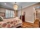 The primary bedroom includes a decorative light fixture, hardwood floors, and large windows at 9 Winnowing Way, Pawleys Island, SC 29585