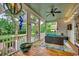 Charming screened porch featuring outdoor seating, a ceiling fan, and peaceful views of the garden at 9 Winnowing Way, Pawleys Island, SC 29585