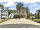 Charming raised beach house with a driveway, covered parking, and inviting staircase leading to the front porch at 914 Dock Pl., Murrells Inlet, SC 29576