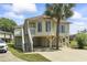 Charming raised beach house with covered parking, and inviting staircase leading to the front porch and walkway at 914 Dock Pl., Murrells Inlet, SC 29576