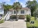 Charming raised beach house with a staircase leading to the front porch and with covered parking and a well-maintained lawn at 914 Dock Pl., Murrells Inlet, SC 29576