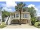 Charming raised beach house with a palm tree, covered parking, and inviting staircase leading to the front porch at 914 Dock Pl., Murrells Inlet, SC 29576