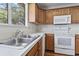 Bright kitchen area features stainless steel sink, and white appliances at 914 Dock Pl., Murrells Inlet, SC 29576