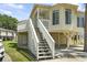 Inviting staircase leading to the front porch of this raised beach house with covered parking underneath at 914 Dock Pl., Murrells Inlet, SC 29576