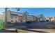 A beige condo building with wood balconies, surrounded by parking spaces and blue skies on a sunny day at 1025 W Plantation Dr. W # 2817, Little River, SC 29566