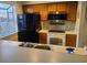 This traditional style kitchen features wood cabinets, black appliances, a dual basin sink, and a window at 1025 W Plantation Dr. W # 2817, Little River, SC 29566