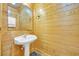 Bathroom with natural wood paneled walls, pedestal sink, and a mirror at 1039 Forest Dr., Conway, SC 29526