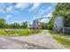 Gravel driveway entrance with decorative metal tanks and wooded surroundings at 1039 Forest Dr., Conway, SC 29526