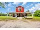 A red barn-style home featuring a covered porch and well-maintained lawn at 1039 Forest Dr., Conway, SC 29526