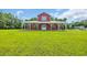 Charming red barn-style home with a white-columned porch and expansive green lawn at 1039 Forest Dr., Conway, SC 29526