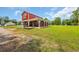 View of the red barn style home with a large porch and green lawn at 1039 Forest Dr., Conway, SC 29526