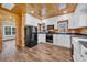 Charming kitchen featuring wood paneled walls and ceiling, white cabinets, modern appliances, and wood grain flooring at 1039 Forest Dr., Conway, SC 29526
