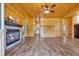 Cozy living room featuring wood paneling, a stone fireplace, and modern flooring at 1039 Forest Dr., Conway, SC 29526