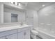 Light-filled bathroom has a white vanity, framed mirror, and tiled shower-tub combination at 1095 Laconic Dr., Myrtle Beach, SC 29588