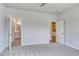 Spacious bedroom featuring neutral carpet, ceiling fan, and doorway to bathroom and kitchenette at 1095 Laconic Dr., Myrtle Beach, SC 29588
