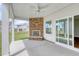 Covered patio features a stone fireplace, ceiling fan, and sliding glass doors at 1095 Laconic Dr., Myrtle Beach, SC 29588