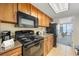 Efficient kitchen with wood cabinets, black appliances, and a dining area with an ocean view at 1105 S Ocean Blvd. # 520, Myrtle Beach, SC 29577