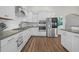 Modern kitchen with white cabinets, granite counters, stainless steel appliances, and a stylish backsplash at 116 Glengrove Lane, Murrells Inlet, SC 29576