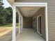 Long, partially covered patio with white pillars and ceiling fans at 118 Westfield Circle, Conway, SC 29526