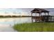 Scenic waterfront view with a charming wooden gazebo and tranquil water, perfect for relaxation at 118 Westfield Circle, Conway, SC 29526
