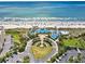 Breathtaking aerial shot of beachfront property, showcasing the sandy beach, blue ocean, and lush landscaping at 135 S Dunes Dr. # 501, Pawleys Island, SC 29585