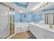 Bright bathroom features a soaking tub, vanity with double sinks and gold fixtures, and a shower with gold trim at 135 S Dunes Dr. # 501, Pawleys Island, SC 29585