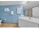 Bathroom with a vanity, sink, and a mirror; towels hang on the blue wall; toilet on the left at 135 S Dunes Dr. # 501, Pawleys Island, SC 29585