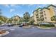 Beautiful condo building exterior featuring tropical landscaping, palm trees, and ample parking at 135 S Dunes Dr. # 501, Pawleys Island, SC 29585