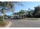 Attractive entrance with a building with a blue roof, palm trees, a well manicured landscape, and ample parking at 135 S Dunes Dr. # 501, Pawleys Island, SC 29585