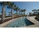 Beautiful water feature with palm trees, a building with a blue roof, and lush landscaping on a sunny day at 135 S Dunes Dr. # 501, Pawleys Island, SC 29585