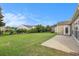 A spacious backyard with well-maintained grass, concrete patio, and a beautiful blue sky above at 15 Saltwind Loop, Murrells Inlet, SC 29576