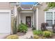 Inviting front entrance with a decorative door, stylish lighting, and lush landscaping, creating a warm and welcoming ambiance at 15 Saltwind Loop, Murrells Inlet, SC 29576