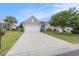 Inviting single-story home features a spacious driveway, lush green lawn, and mature landscaping, creating a welcoming curb appeal at 15 Saltwind Loop, Murrells Inlet, SC 29576