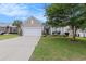 Attractive single-story home with a well-kept lawn, mature landscaping, and a long driveway leading to an attached two-car garage at 15 Saltwind Loop, Murrells Inlet, SC 29576
