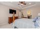 Bright main bedroom with a tray ceiling, ceiling fan, wood furniture, and ensuite bathroom at 15 Saltwind Loop, Murrells Inlet, SC 29576