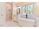 Bright bathroom with a soaking tub, marble shower, single vanity, and a large window providing natural light at 155 Mckenzie Circle, Pawleys Island, SC 29585