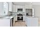 Contemporary kitchen with stainless steel appliances, white cabinets, and a tile backsplash at 155 Mckenzie Circle, Pawleys Island, SC 29585