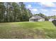 Expansive fenced backyard with lush green grass and a screened-in porch at 1600 Palmetto Palm Dr., Myrtle Beach, SC 29579