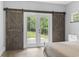 View of a bedroom with sliding barn doors that lead to the backyard at 1600 Palmetto Palm Dr., Myrtle Beach, SC 29579