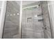 Modern shower with gray tiling, built-in niche, and glass door at 1600 Palmetto Palm Dr., Myrtle Beach, SC 29579