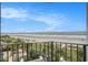 View from the balcony overlooking a white sandy beach, the ocean, and lush vegetation at 1605 S Ocean Blvd. # 204, Myrtle Beach, SC 29577