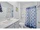 Bright bathroom featuring a shower, tub, vanity with sink and a matching blue shower curtain at 1723 Perthshire Loop, Myrtle Beach, SC 29579