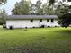 Expansive backyard with a well-maintained lawn and a white brick exterior provides ample outdoor space at 1903 Rose St., Conway, SC 29527