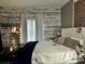 Bright primary bedroom offers a comfortable bed, brick wall accent, and plenty of natural light at 1903 Rose St., Conway, SC 29527