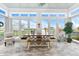 Bright sunroom featuring large windows with views of the lake and a rustic wooden table and bench at 201 West Isle Of Palms Ave., Myrtle Beach, SC 29579