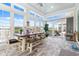 Bright sunroom featuring large windows with views of the lake and a rustic wooden table and bench at 201 West Isle Of Palms Ave., Myrtle Beach, SC 29579