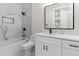 A modern bathroom features white cabinets, marble counters and shower, and black hardware at 2205 Yellow Morel Way, Myrtle Beach, SC 29579