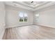 Spacious bedroom with tray ceilings, neutral paint, hardwood floors, and large windows at 2205 Yellow Morel Way, Myrtle Beach, SC 29579